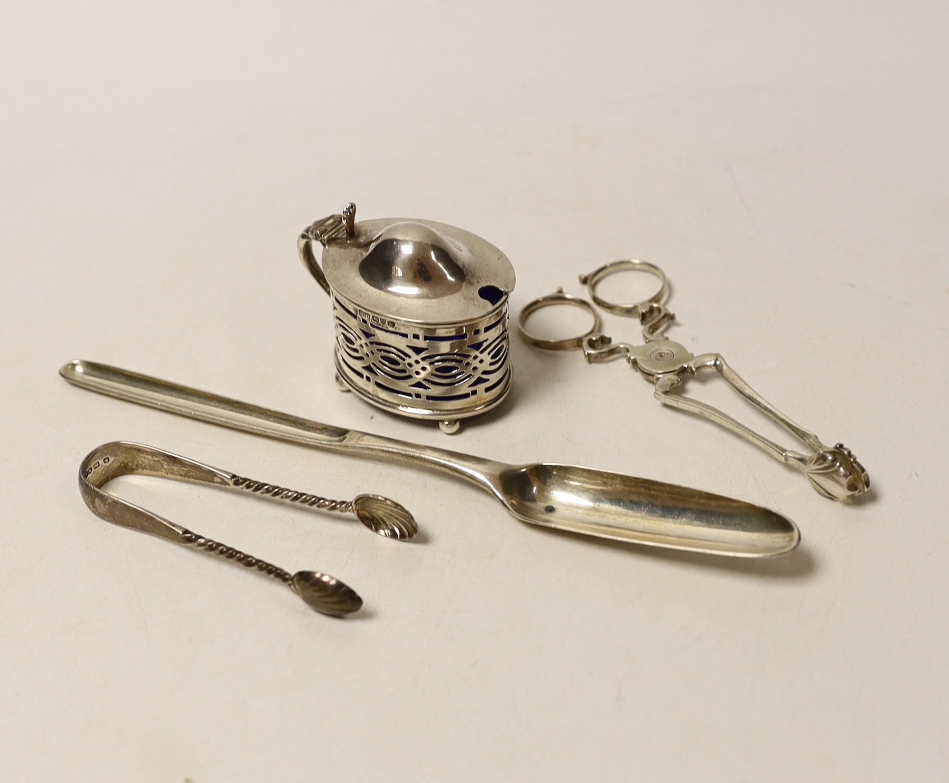 A George III silver marrow scoop, Stephen Adam, London, 1772, 21.5cm, a pair of mid to late 18th century silver sugar nips, a later silver mustard and pair of silver sugar tongs.